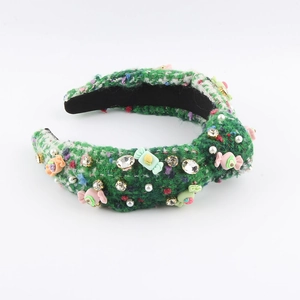 Détail d'un serre-tête en tweed vert avec cristaux brillants et ornements en résine candy