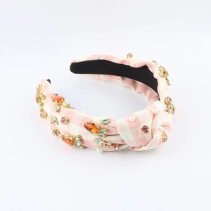 Dettaglio di cerchietto rosa a quadretti vichy con strass colorati e perle bianche