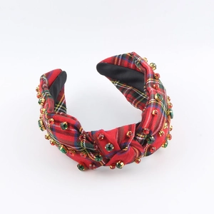 Close-up of red plaid fabric headband with colorful rhinestones in gold metal claws