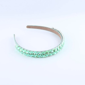 Close-up of light green crystal leaf headband with intricate rhinestone wheat ear pattern