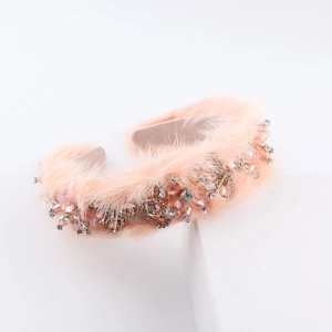 Macro shot of luxury pink faux fur headband with intricate crystal flower and butterfly patterns