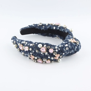 Detail eines Jeans-Haarreifens mit rosa Steinen, weißen Perlen und floralen Akzenten
