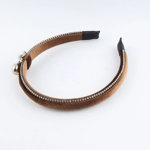 Close-up of brown velvet headband with sparkling rhinestones and white pearl accents
