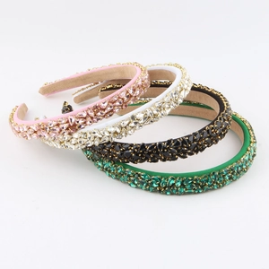 Détails de quatre serre-têtes en strass étincelants de différentes couleurs avec chaîne dorée