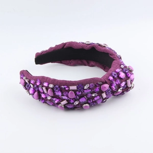 Détail d'un serre-tête baroque violet foncé orné de cristaux et de perles étincelantes