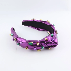 Gros plan du serre-tête noué en cuir violet avec perles colorées et strass vert émeraude