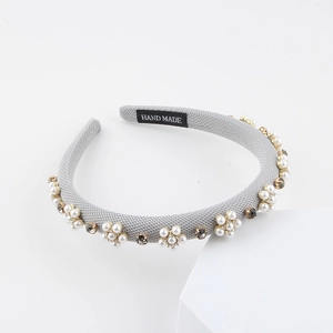 Baroque gray fabric headband with pearl flowers and rhinestones on a white pedestal