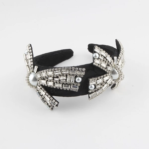 Close-up of sparkling crystals and pearls on a luxury wide black fabric headband