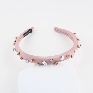 Serre-tête rembourré rose avec strass et perles blanches sur support blanc