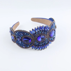 Macro shot of blue rhinestones and gold metal base on a baroque headband detail
