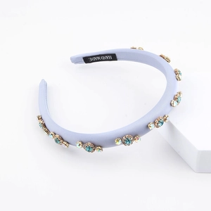 Fashionable purple satin headband with blue rhinestones and handmade label on white prop