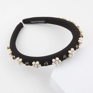 Detail of handmade baroque headband featuring fabric texture, pearls, and black gems