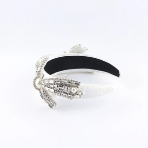 Luxurious white headband featuring a crystal bow and faux pearls in an elegant style