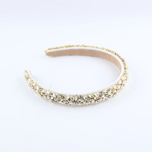 Vue détaillée du serre-tête large orné de strass brillants sur base en métal doré