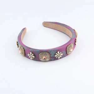 Serre-tête baroque en satin violet avec cristaux et perles sur fond blanc