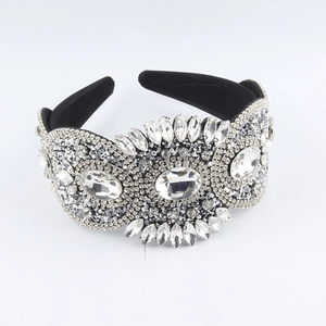 Detail view of baroque wide headband with heavy crystal rhinestones on black fabric