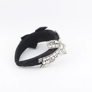 Detail of luxury headband featuring sparkling rhinestones and pearls on black fabric