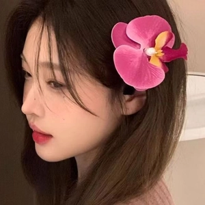 Dettaglio del fermaglio per capelli con orchidea rosa e perla su una modella