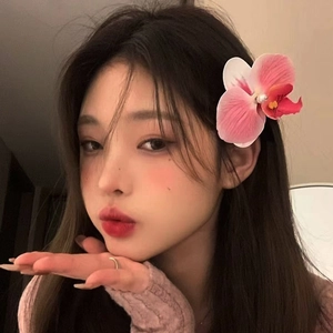 Dettaglio del fermaglio per capelli a orchidea rosa con perla su acconciatura