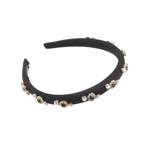 Fashionable black padded sponge headband with rhinestone flower decor on white background