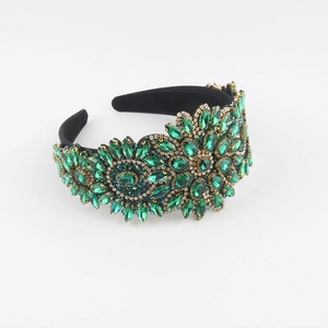 Close-up of green rhinestone flower headband with vintage baroque gold metal details