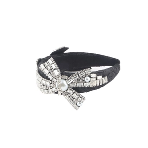 Elegant black headband with heavy rhinestone and pearl bow ornament on white background