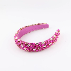 Detailed view of baroque wide headband with layered rose red and pink crystals on satin