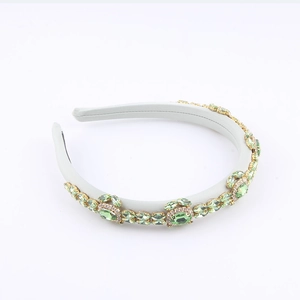 Détail du serre-tête en cristal avec pierres vert olive et griffes en métal doré