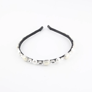 Detail view of pearl and crystal beaded headband with black frame on white background