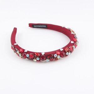 Detailed macro view of handmade burgundy velvet headband with multi-colored rhinestones