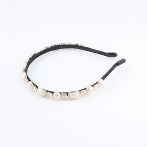 Detail of luxury hairband with pearls and champagne rhinestones on black fabric base