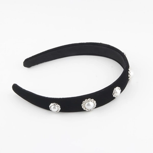 Close-up of black velvet wide headband with large faux pearls in vintage silver floral bases