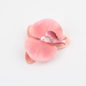 Dettaglio di un fermaglio per capelli a orchidea rosa sfumato con perla sintetica centrale