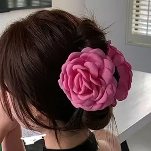 Grande molletta per capelli a forma di rosa fucsia indossata con uno chignon stile coreano