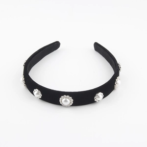 Detail of black velvet headband featuring five faux pearls in ornate floral metal settings