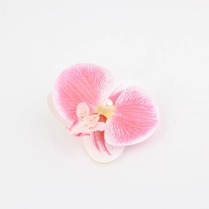Dettaglio del fermaglio a orchidea rosa con petali sfumati e una perla centrale bianca