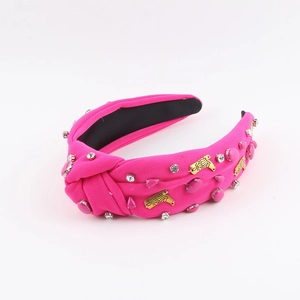 Detail of bright pink knotted headband with silver rhinestones and gold boot charm