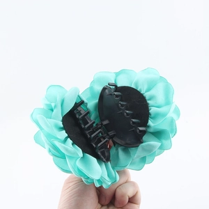 Pinza per capelli a rosa 3D verde menta con impugnatura nera tenuta in mano