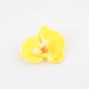 Dettaglio del fermaglio per capelli orchidea gialla con texture e perla bianca al centro