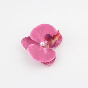 Dettaglio macro di un fermaglio per capelli a orchidea con petali rosa e perla
