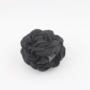 Dettaglio del fermaglio per capelli a rosa in tessuto nero con petali 3D stratificati
