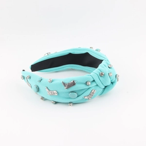 Detail of mint green knotted headband with knit texture, sparkling rhinestones and boot charms