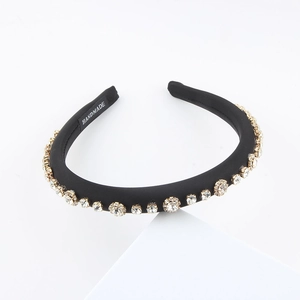 Detail of handmade black fabric headband featuring sparkling rhinestones in gold metal claws