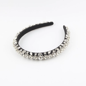 Close-up of hand-sewn rhinestones on a black baroque sponge headband for elegant events