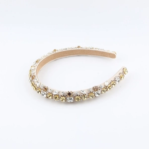 Macro detail of hand-sewn baroque headband with sparkling amber and gold rhinestones