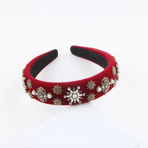 Détail du serre-tête en velours rouge avec motifs baroques en perles et strass brillants