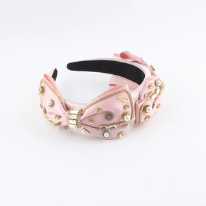 Detail of pink satin headband featuring crystals, pearls, and vintage gold patterns