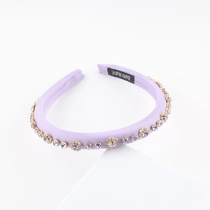 Detailed view of light purple satin headband with rhinestones and handmade label