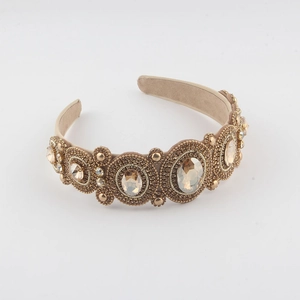 Close-up of champagne Baroque headband featuring large crystals and gold beadwork detail