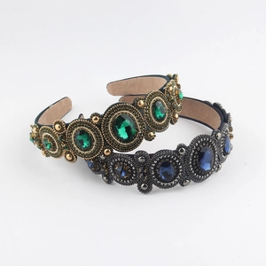 Detail of baroque headbands featuring emerald and sapphire gemstones with intricate beadwork